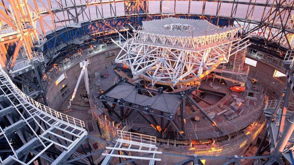 Innenansicht einer großen kreisförmigen Struktur im Bau, die mit Metallträgern gefüllt ist, um das Skelett der Struktur zu bilden.