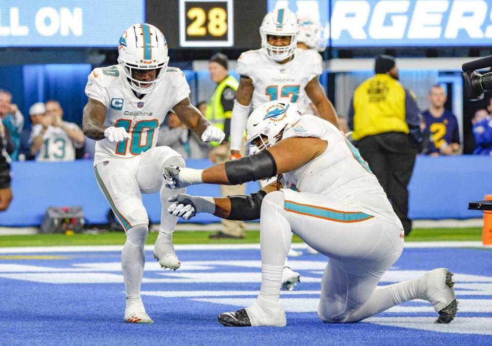 Miami Dolphins wide receiver Tyreek Hill (10) and offensive tackle Robert Hunt (68) celebrate after catching a pass to score against the Los Angeles Chargers in the fourth quarter at SoFi Stadium in Inglewood, California on Sunday, December 11, 2022.