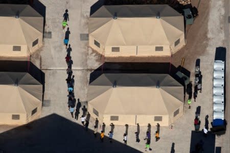 FILE PHOTO: Immigrant children are led by staff in single file between tents at a detention facility next to the Mexican border in Tornillo, Texas, U.S., June 18, 2018. Picture taken June 18, 2018. REUTERS/Mike Blake