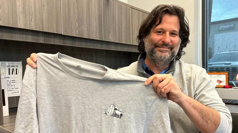 Parks Robinson shows one of the shirts given to Fit2Run managers after the company purchased the former Champs Sports complex at 311 Manatee Ave. W., Bradenton. The shirt includes a logo of the property.