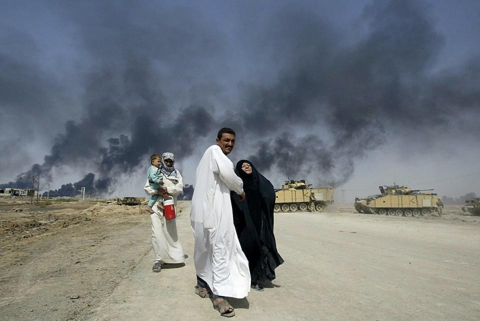 An Iraqi family flees past British tanks from the city of Basra in March 2003. <a href="https://media.gettyimages.com/id/939686156/photo/iraq-us-war-basra.jpg?s=1024x1024&w=gi&k=20&c=8oY0CUTwfwFeWjzVGvTIpSULsSMsitwoXNPB1NnCleY=" rel="nofollow noopener" target="_blank" data-ylk="slk:Odd Andersen/AFP via Getty Images;elm:context_link;itc:0;sec:content-canvas" class="link ">Odd Andersen/AFP via Getty Images</a>