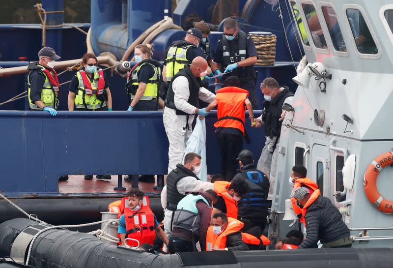 Migrants disembark after arriving at Dover harbour, in Dover