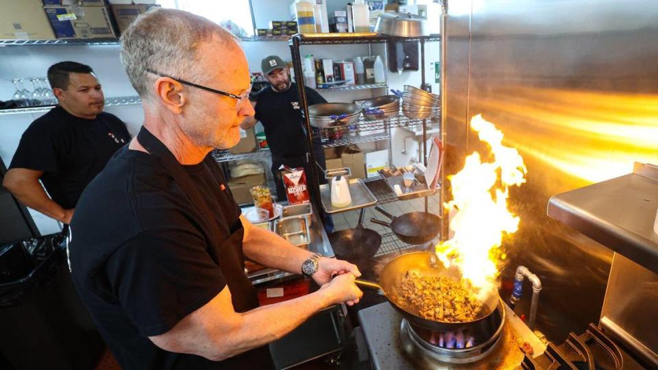 John MacKinnon shows how some ingredients are cooked in a wok for better flavor. He has opened Todo Bueno, the All Good Grill upstairs at the San Luis Obispo Public Market.