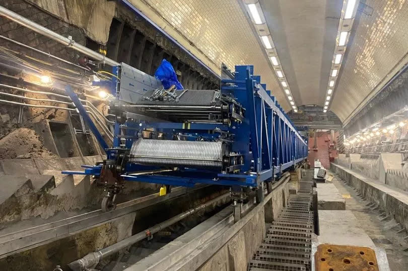 An escalator at Kentish Town station with a blue machine on top of it