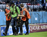 A protestor is escorted by stewards before the Euro 2020 soccer championship group F match between France and Germany at the Allianz Arena stadium in Munich, Tuesday, June 15, 2021. (Matthias Hangst/Pool via AP)