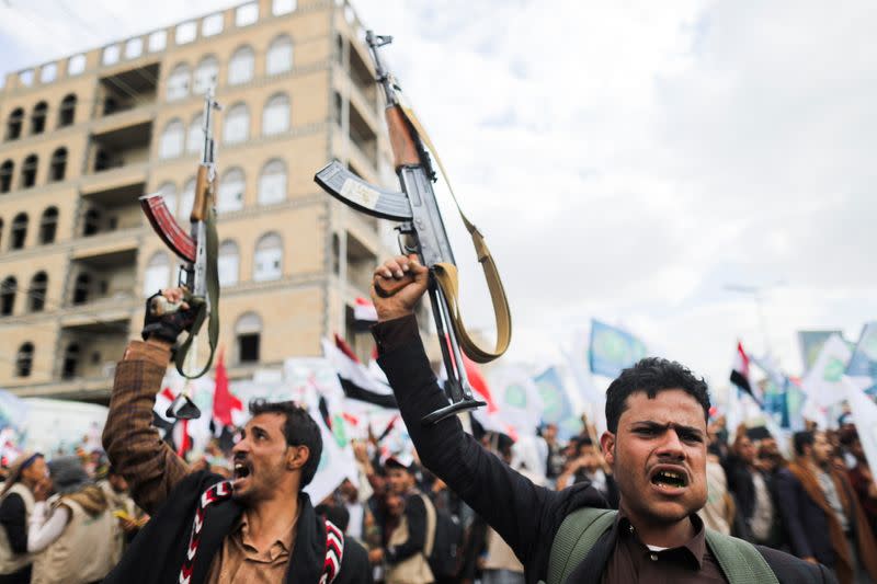 Supporters of Yemen's Houthis hold up their rifles as they rally to celebrate the seventh anniversary of the ousting of the government in Sanaa