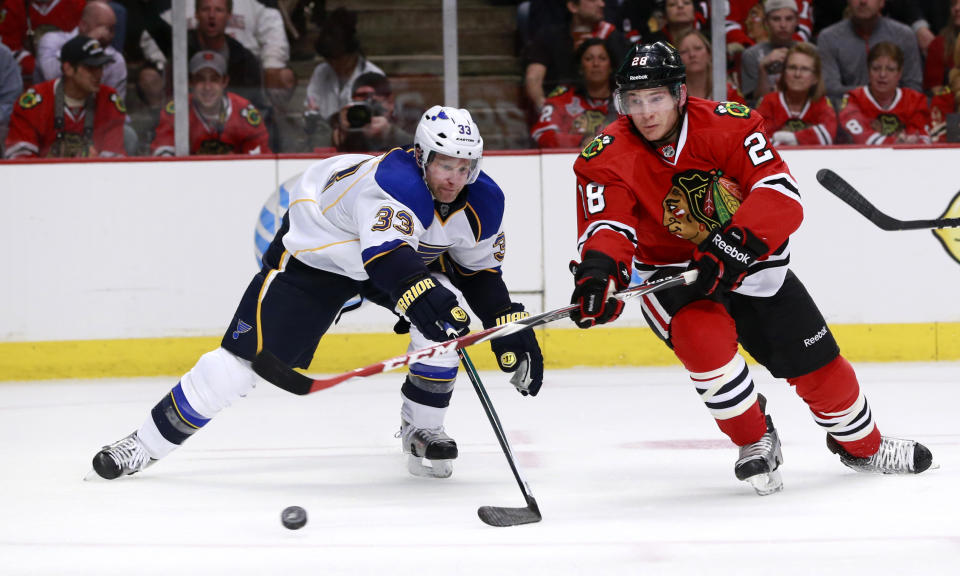 Chicago Blackhawks right wing Ben Smith (28) takes a backhanded shot on goal past St. Louis Blues defenseman Jordan Leopold during the second period in Game 3 of a first-round NHL hockey Stanley Cup playoff series game Monday, April 21, 2014, in Chicago. (AP Photo/Charles Rex Arbogast)