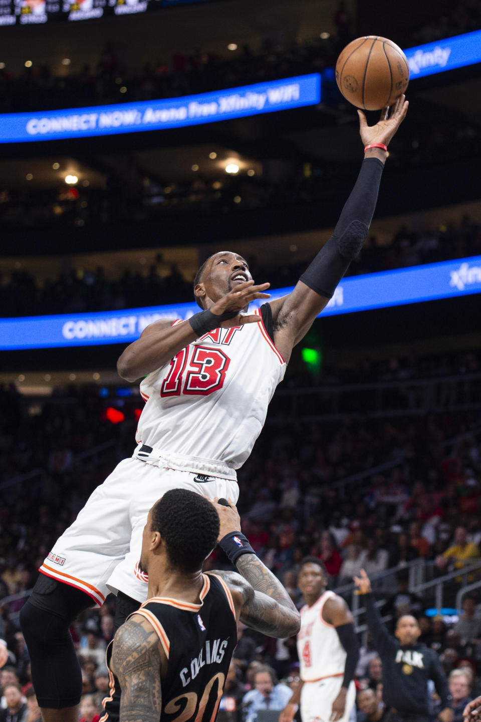 Miami Heat center Bam Adebayo, top, goes up to score and knocks down Atlanta Hawks forward John Collins during the second half of an NBA basketball game, Monday, Jan. 16, 2023, in Atlanta. (AP Photo/Hakim Wright Sr.)