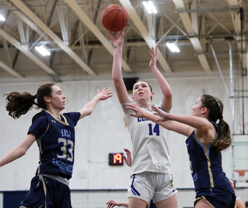 Norwell's Madison Oliver, takes a shot at the basket between East Bridgewater defenders from left, Shania Gardner and Jenna Oman during a game on Tuesday, March 5, 2024.