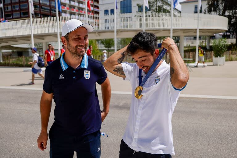 "¿A ver cómo me queda?", bromea el "Maligno" Torres, junto con su técnico, Maximiliano Benadía, en la zona internacional de la Villa Olímpica