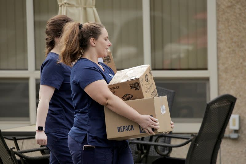 FILE PHOTO: Healthcare workers carry Clorox wipes and other supplies into the Life Care Center of Kirkland, the long-term care facility linked to several confirmed coronavirus cases in the state, in Kirkland