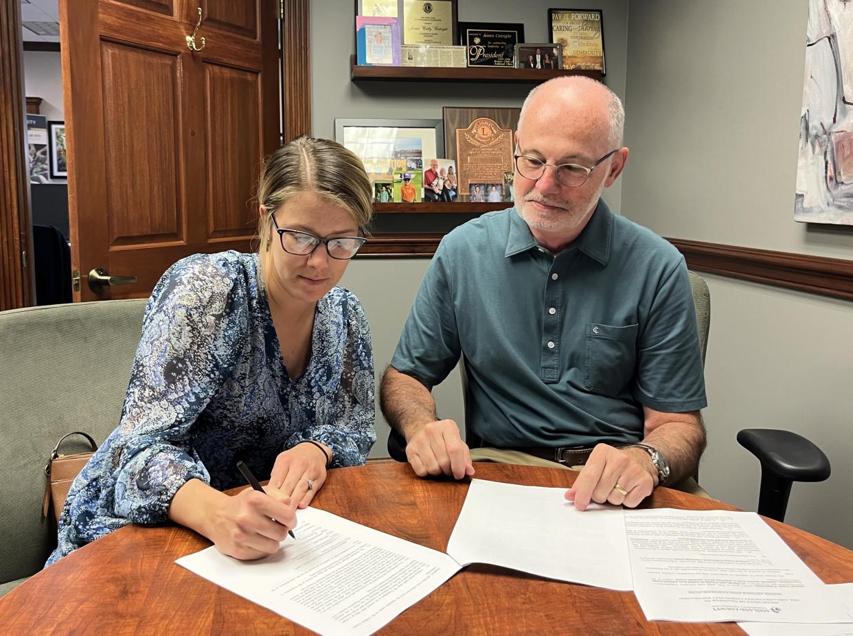 Emily Grimm and Jim Cutright sign a transfer document to establish Ashland Young Professionals’ new donor advised fund at Ashland County Community Foundation.