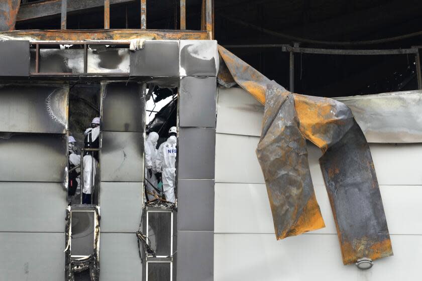 Members of the National Forensic Service Investigate the site of a burnt battery manufacturing factory in Hwaseong, South Korea, Tuesday, June 25, 2024. (AP Photo/Lee Jin-man)