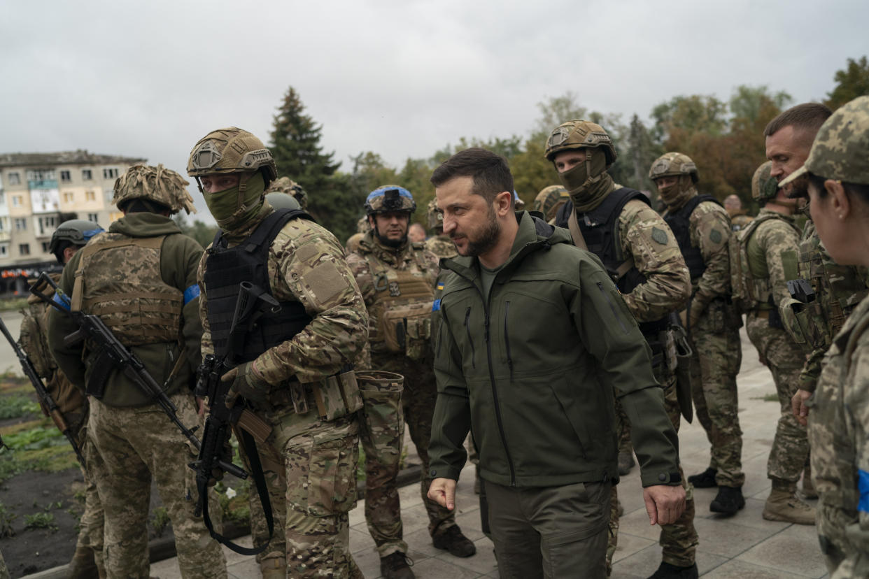 Surrounded by soldiers the Ukrainian President Volodymyr Zelenskyy attends a national flag-raising ceremony in the freed Izium, Ukraine, Wednesday, Sept. 14, 2022. Zelenskyy visited the recently liberated city on Wednesday, greeting soldiers and thanking them for their efforts in retaking the area, as the Ukrainian flag was raised in front of the burned-out city hall building. (AP Photo/Leo Correa)