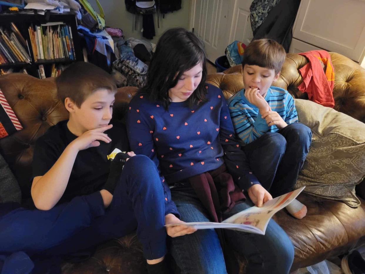 Erin Geddes’ children read a copy of her book “And That’s Okay: I’m Wired Differently.” All three of her children have been diagnosed on the autism spectrum. Photo by Erin Geddes, Photo Provided