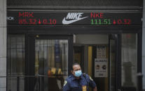 A security agent exits the New York Stock Exchange building as a ticker above the doorway carries the latest trading information, Tuesday Aug. 25, 2020, in New York. U.S. stocks are drifting close to their record heights Tuesday, as momentum slows on Wall Street. (AP Photo/Bebeto Matthews)
