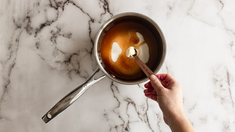Adding butter to toffee in saucepan
