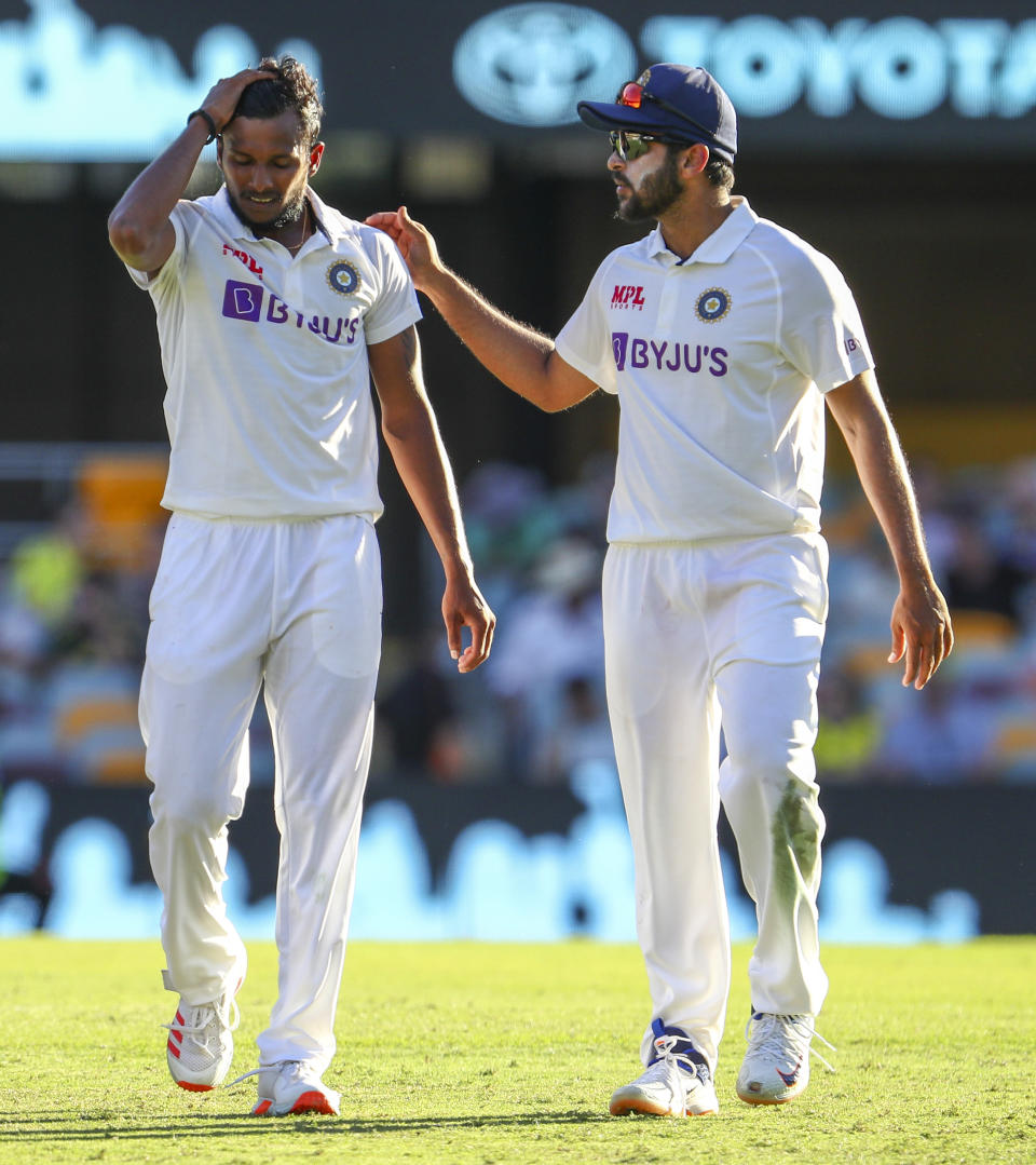 India's Thangarasu Natarajan, left, and India's Shardul Thakur talk during play on the first day of the fourth cricket test between India and Australia at the Gabba, Brisbane, Australia, Friday, Jan. 15, 2021. (AP Photo/Tertius Pickard)