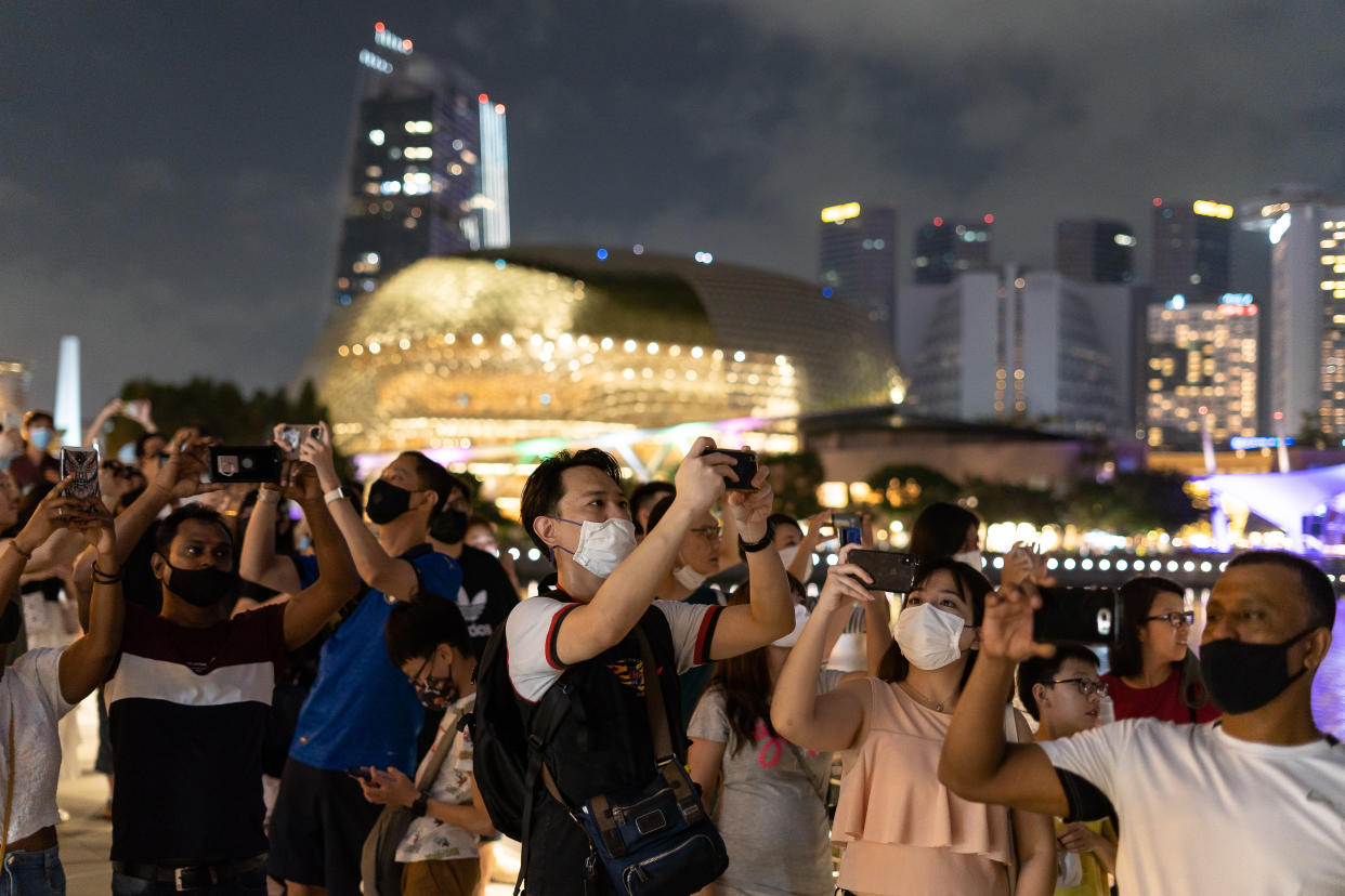 SINGAPORE, SINGAPORE - JANUARY 01: People flock to Marina bay area to watch light shows to usher in the new year amid coronavirus (Covid-19) pandemic in Singapore on January 1, 2021. Although there was no firework show, people gathered at city center. (Photo by Zakaria Zainal/Anadolu Agency via Getty Images)