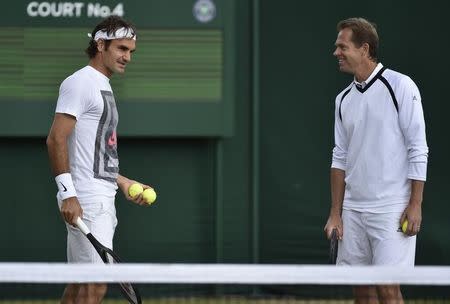 Roger Federer of Switzerland (L) speaks with his coach Stefan Edberg during a practice session at the Wimbledon Tennis Championships in London July 5, 2014. REUTERS/Toby Melville