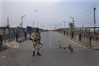 An Indian paramilitary force soldier stands guard near a barbed wire barricade during restrictions in Srinagar Indian controlled Kashmir, Friday, Sept. 27, 2019. Residents in Indian-controlled Kashmir waited anxiously as Indian and Pakistani leaders were scheduled to speak at the U.N. General Assembly later Friday. (AP Photo/ Dar Yasin)