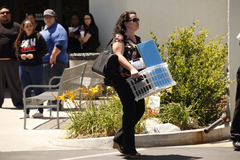 CITY OF INDUSTRY, CA  APRIL 27, 2015 -- Teacher Christina Ledoux carries her belongings as Students gathered with teachers that came to collect their personal items at Everest College in City of Industry, one of the Corinthian Colleges that closed on Monday. April 27, 2015. (Al Seib / Los Angeles Times via Getty Images)