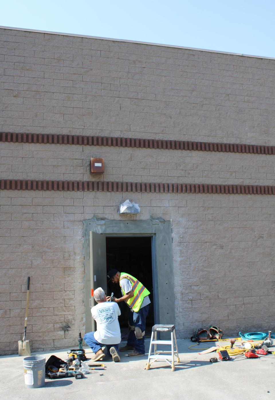 Workers repair the side entrance to Smokin Barrel, a Simi Valley gun shop, on July 11, two days after burglars tried unsuccessfully to ram a Kia sedan into the entrance.