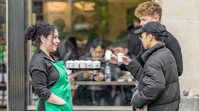 Starbucks employee handing out hot chocolate