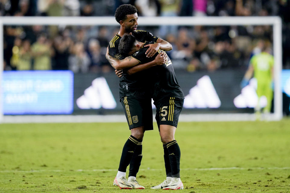 Los Angeles FC midfielder Timothy Tillman, left, and forward Cristian Olivera embrace after the team's win over the Vancouver Whitecaps during an MLS playoff soccer match Saturday, Oct. 28, 2023, in Los Angeles. (AP Photo/Ryan Sun)