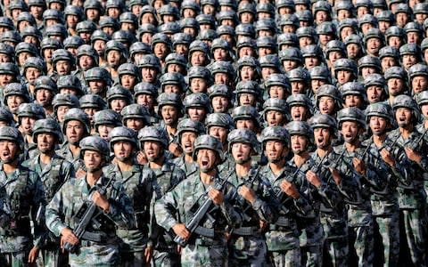 Soldiers of China's People's Liberation Army (PLA) get ready for the military parade to commemorate the 90th anniversary of the foundation of the army at Zhurihe military training base  - Credit: Reuters