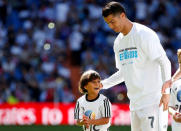 Zaid, son of Osama Abdul Mohsen, smiles as he stands next to Real Madrid's Cristiano Ronaldo before the Spanish first division soccer match against Granada at Santiago Bernabeu stadium in Madrid, Spain, September 20, 2015. REUTERS/Sergio Perez/File Photo