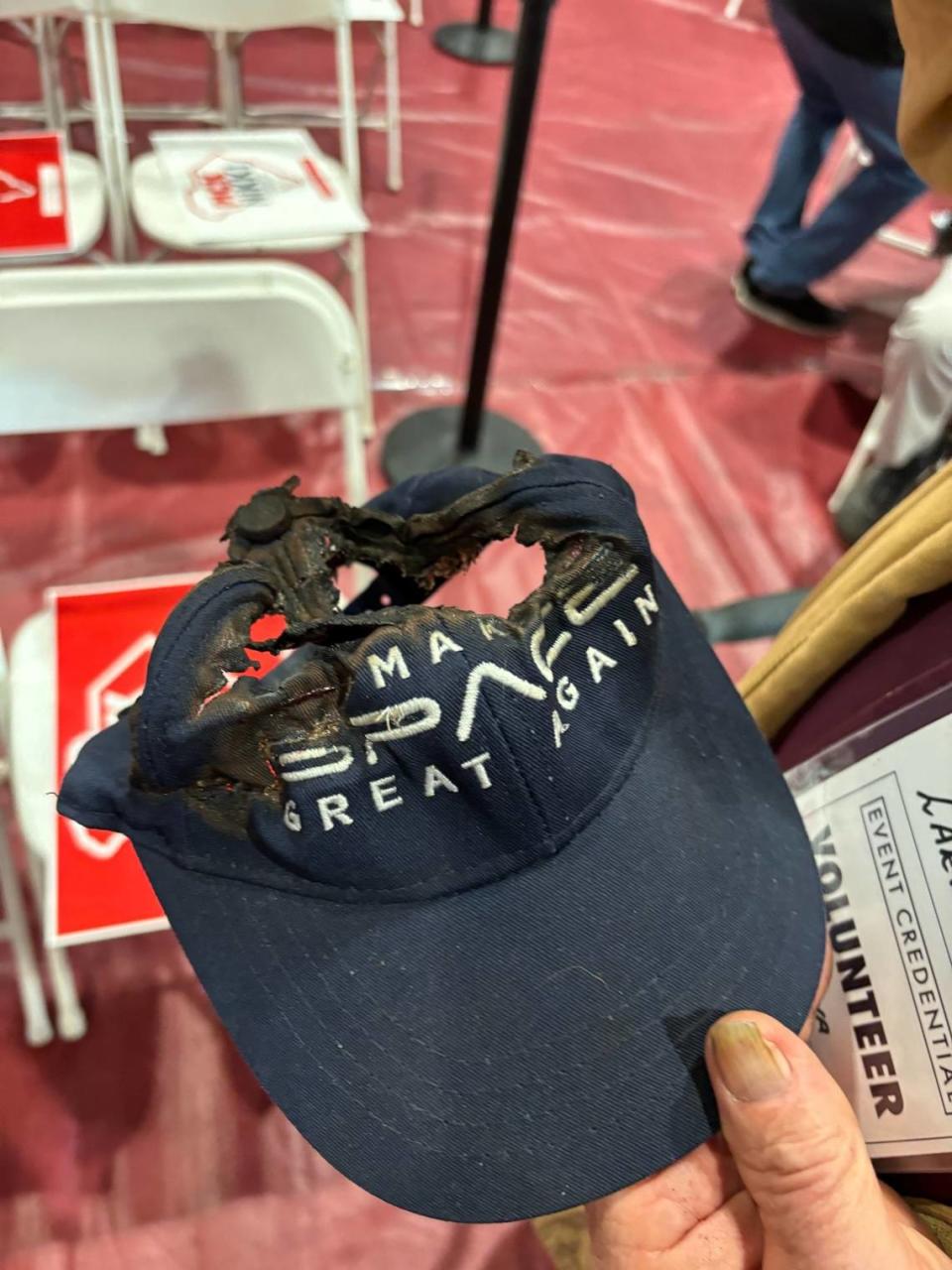 Larry Hall holds a Donald Trump “Make Space Great Again” hat. He has burned it prior to attending the rally. It was still wet and smelled singed.