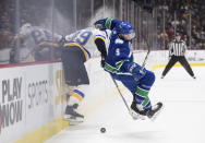 Vancouver Canucks' J.T. Miller, right, loses his footing while vying for the puck against St. Louis Blues' Ivan Barbashev, of Russia, during the first period of an NHL hockey game in Vancouver, British Columbia on Monday Jan. 27, 2020. (Darryl Dyck/The Canadian Press via AP)