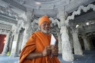 Hindu monk, Swami Akshaymunidas, one of the main designers of the temple, poses for a photo under the dome of the first stone-built Hindu temple in Abu Mureikha, 40 kms, 25 miles, northeast of Abu Dhabi, United Arab Emirates, Monday, Feb. 12, 2024. The soon-to-open BAPS Hindu Mandir signals just how far the United Arab Emirates has come in acknowledging the different faiths of its expatriate community, long dominated by Indians who power life across its construction sites and boardrooms. (AP Photo/Kamran Jebreili)