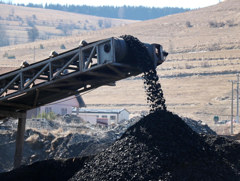 Coal  falling from the moving belt conveyor into the big pile, at the coal mine