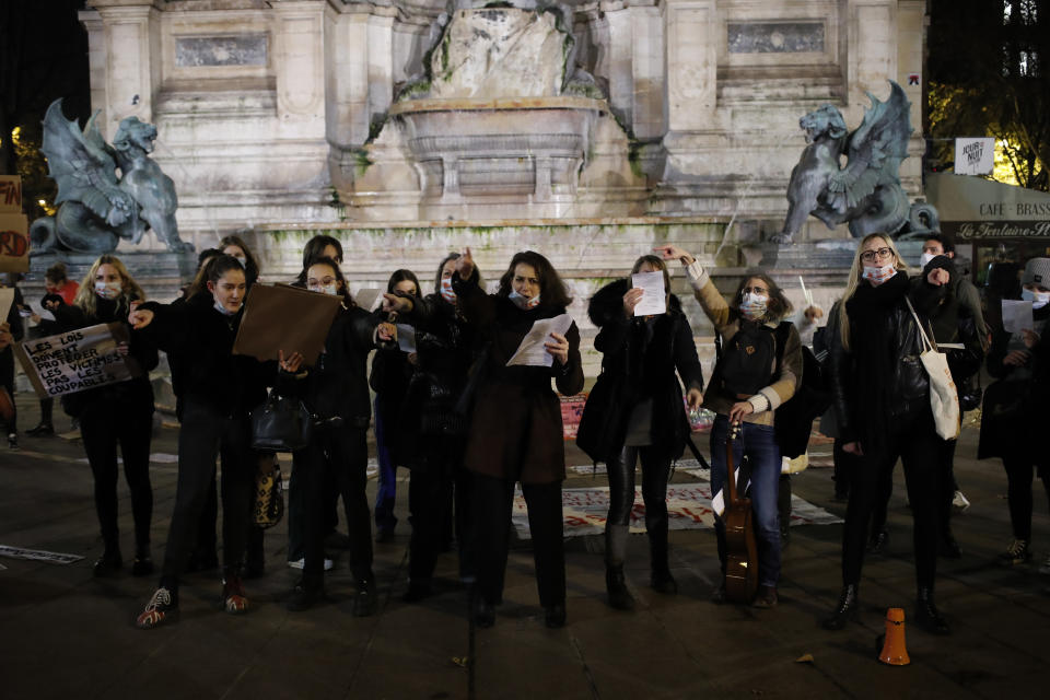 Women gather at the Saint Michel fountain Wednesday, Nov. 25, 2020 in Paris. With domestic violence on the rise amid the pandemic, activists are holding protests Wednesday from France to Turkey and world dignitaries are trying to find ways to protect millions of women killed or abused every year by their partners. (AP Photo/Francois Mori)