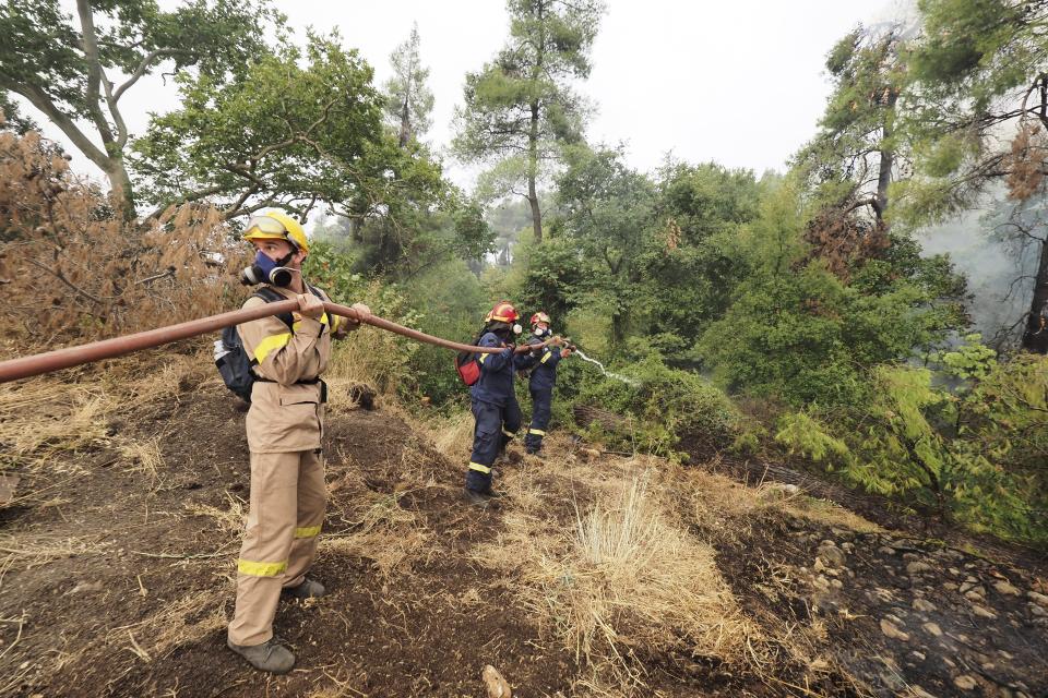 Firefighters try to extinguish a wildfire in Kechries village on the island of Evia, about 144 kilometers (90 miles) north of Athens, Greece, Thursday, Aug. 5, 2021. Forest fires fueled by a protracted heat wave raged overnight and into Thursday in Greece, threatening the archaeological site at the birthplace of the modern Olympics and forcing the evacuation of dozens of villages. (AP Photo/Thodoris Nikolaou)