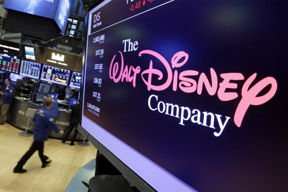 FILE - In this Aug. 8, 2017, file photo, The Walt Disney Co. logo appears on a screen above the floor of the New York Stock Exchange. On Tuesday, Nov. 12, Disney Plus launches its streaming service. (AP Photo/Richard Drew, File)