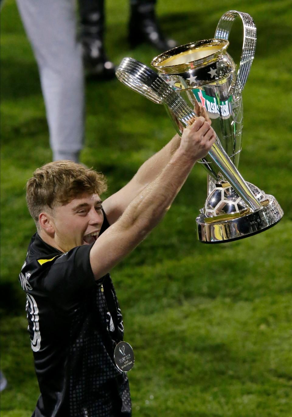 Columbus Crew midfielder Aidan Morris (21) holds up the trophy as he celebrates a 3-0 win over the Seattle Sounders FC in the MLS Cup championship soccer match at Mapfre Stadium in Columbus, Oh. on Saturday, December 12, 2020.