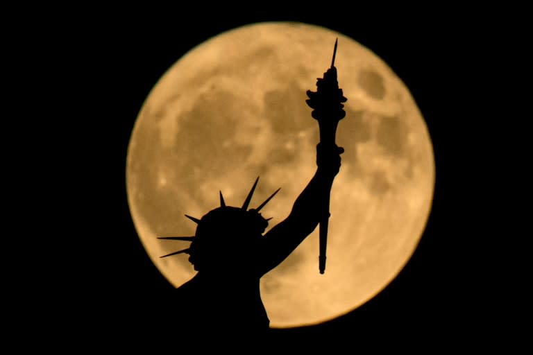 The "supermoon" is seen above a statue at the top of the Nature and History Museum on November 14, 2016 in Vienna, Austria