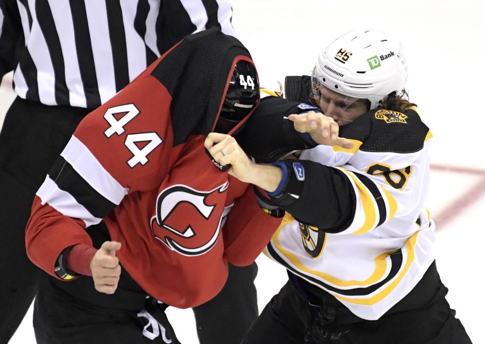 Boston Bruins defenseman Kevan Miller, right, fights with New Jersey Devils left wing Miles Wood (44) during the first period of an NHL hockey game Saturday, Jan. 16, 2021, in Newark, N.J. (AP Photo/Bill Kostroun)