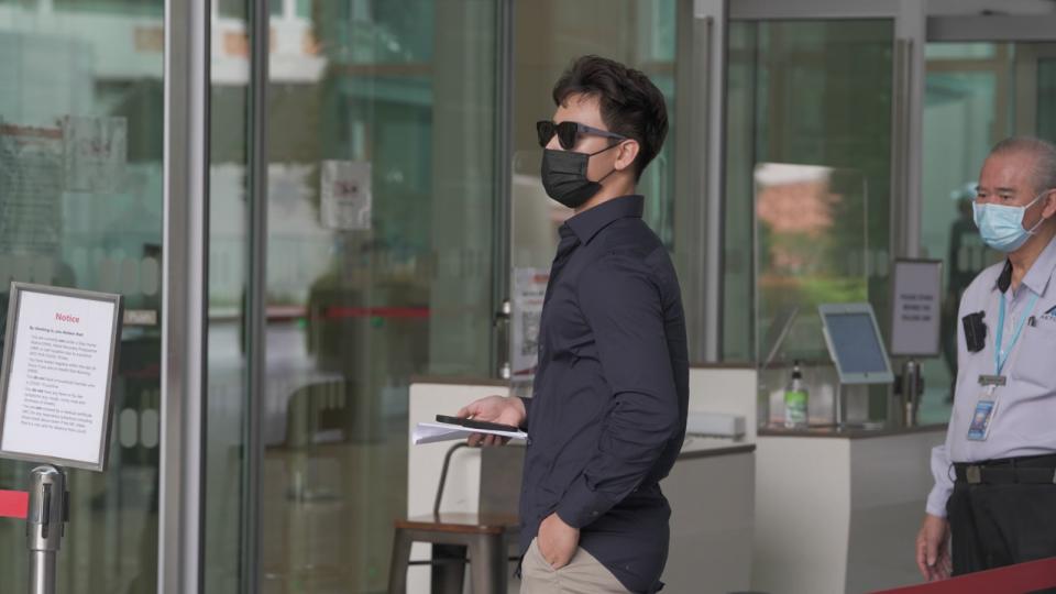 Influencer Titus Low appears at the courts to face charges of transmitting obscene material on OnlyFans. (PHOTO: Nick Tan/Yahoo News Singapore)