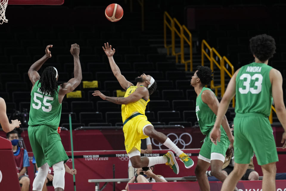 Australia's Patty Mills, center shoots over Nigeria's Precious Achiuwa (55) during a men's basketball preliminary round game at the 2020 Summer Olympics, Sunday, July 25, 2021, in Saitama, Japan. (AP Photo/Eric Gay)