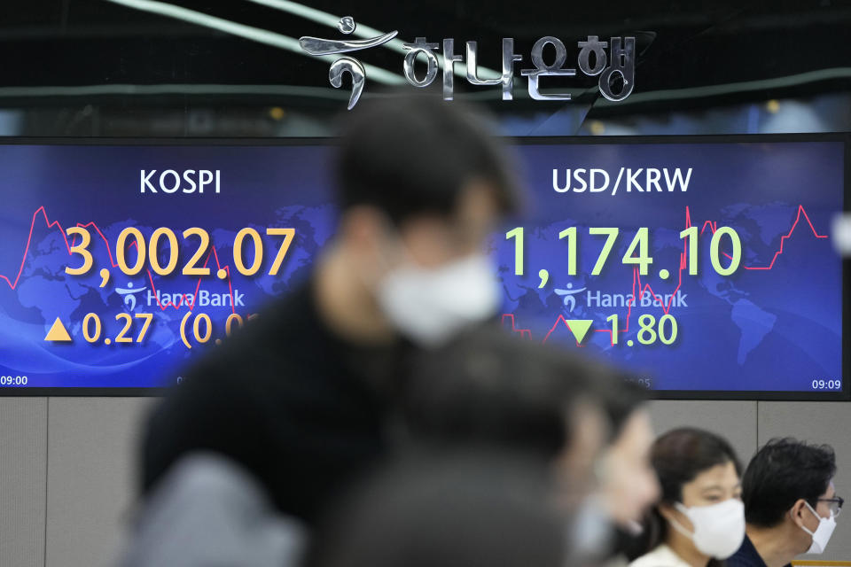 Currency traders watch computer monitors near the screens showing the Korea Composite Stock Price Index (KOSPI), left, and the foreign exchange rate between U.S. dollar and South Korean won at a foreign exchange dealing room in Seoul, South Korea, Thursday, Dec. 9, 2021. Asian stock markets followed Wall Street higher Thursday as investors waited for U.S. inflation data that might influence the Federal Reserve's decision on when to roll back economic stimulus. (AP Photo/Lee Jin-man)