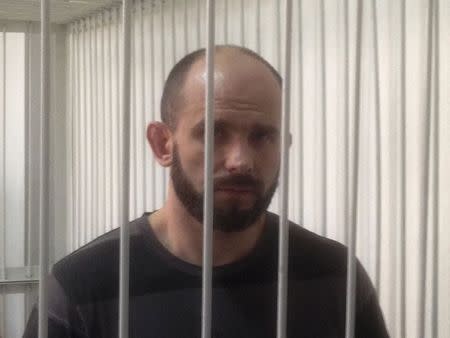 Ex-Berkut commander Dmytro Sadovnyk stands inside a metal cage during a court hearing in Kiev September 5, 2014. REUTERS/Steve Stecklow
