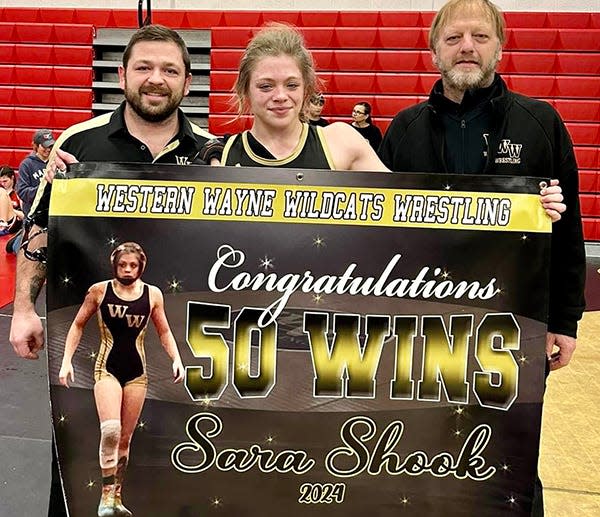 Western Wayne senior Sara Shook recently notched the 50th win of her varsity wrestling career. She is pictured here with coaches Josh Harrison (left) and Ed Harrison (right).
