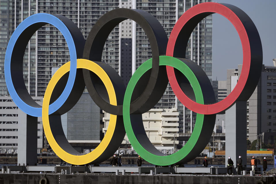 FILE - In this Dec. 1, 2020, file photo, the Olympic Symbol is reinstalled after it was taken down for maintenance ahead of the postponed Tokyo 2020 Olympics in the Odaiba section, in Tokyo. The official cost of the postponed Tokyo Olympics has increased by 22%, the local organizing committee said Tuesday, Dec. 22, 2020, in unveiling its new budget. (AP Photo/Eugene Hoshiko, File)