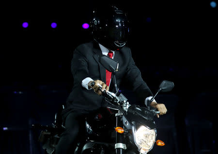 2018 Asian Games – Opening ceremony - GBK Main Stadium – Jakarta, Indonesia – August 18, 2018 – An actor impersonating Indonesia's President Joko Widodo rides a motorbike. REUTERS/Cathal Mcnaughton