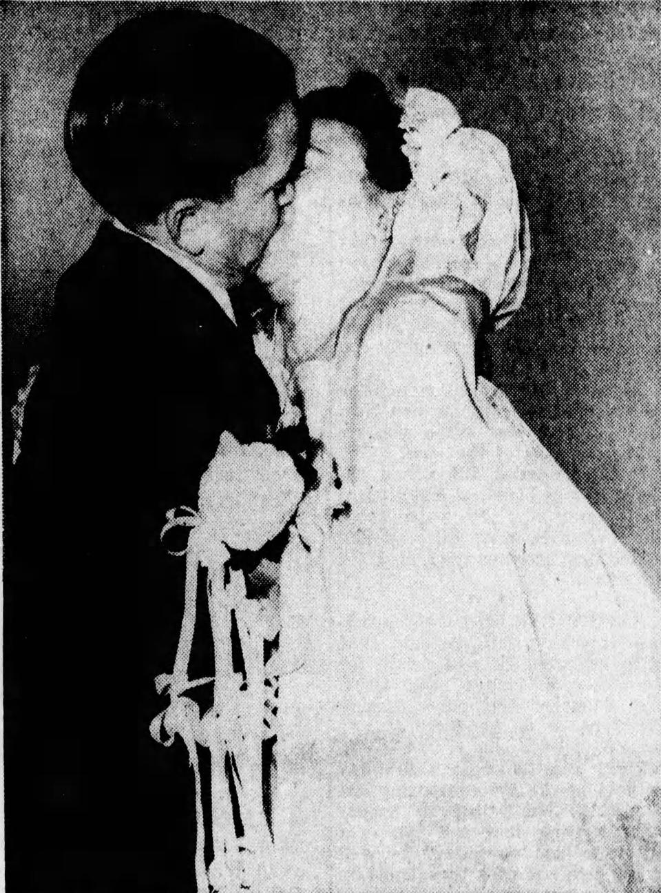 Meinhardt Raabe kisses his bride, Marie, on Dec. 15, 1946, at East Market Street Church of Christ in Akron. The wedding made front-page news in the Beacon Journal.