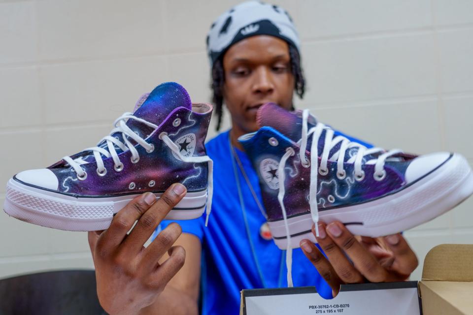 Malcolm Goggans, a former Boys & Girls Club student, now works at the Keenan-Stahl Boys & Girls Club in Indianapolis' Near Southeast neighborhood. In the afternoon Monday, Dec. 12, 2022, as students begin to arrive to the club, Goggans talks about his journey as a custom shoe designer. He says he kept to himself as a younger teen and would spend hours in his bedroom painting designs on various sneakers. As his passion grew so did his skill. Goggans recently helped oversee the club's first sneaker design contest that lead up to their Blue Door Gala.